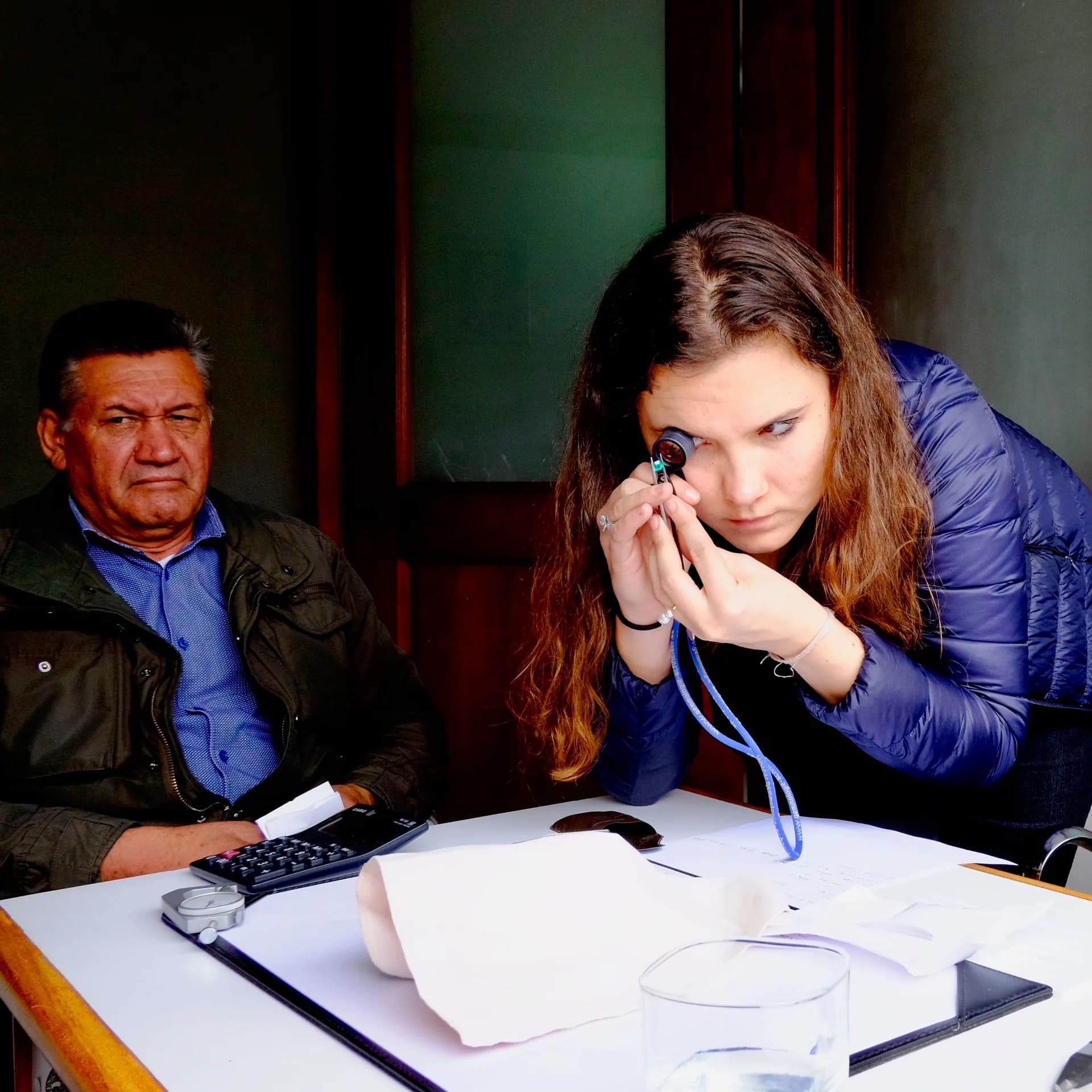 Examen d'une émeraude à la loupe dans un bureau de courtier à Bogotá