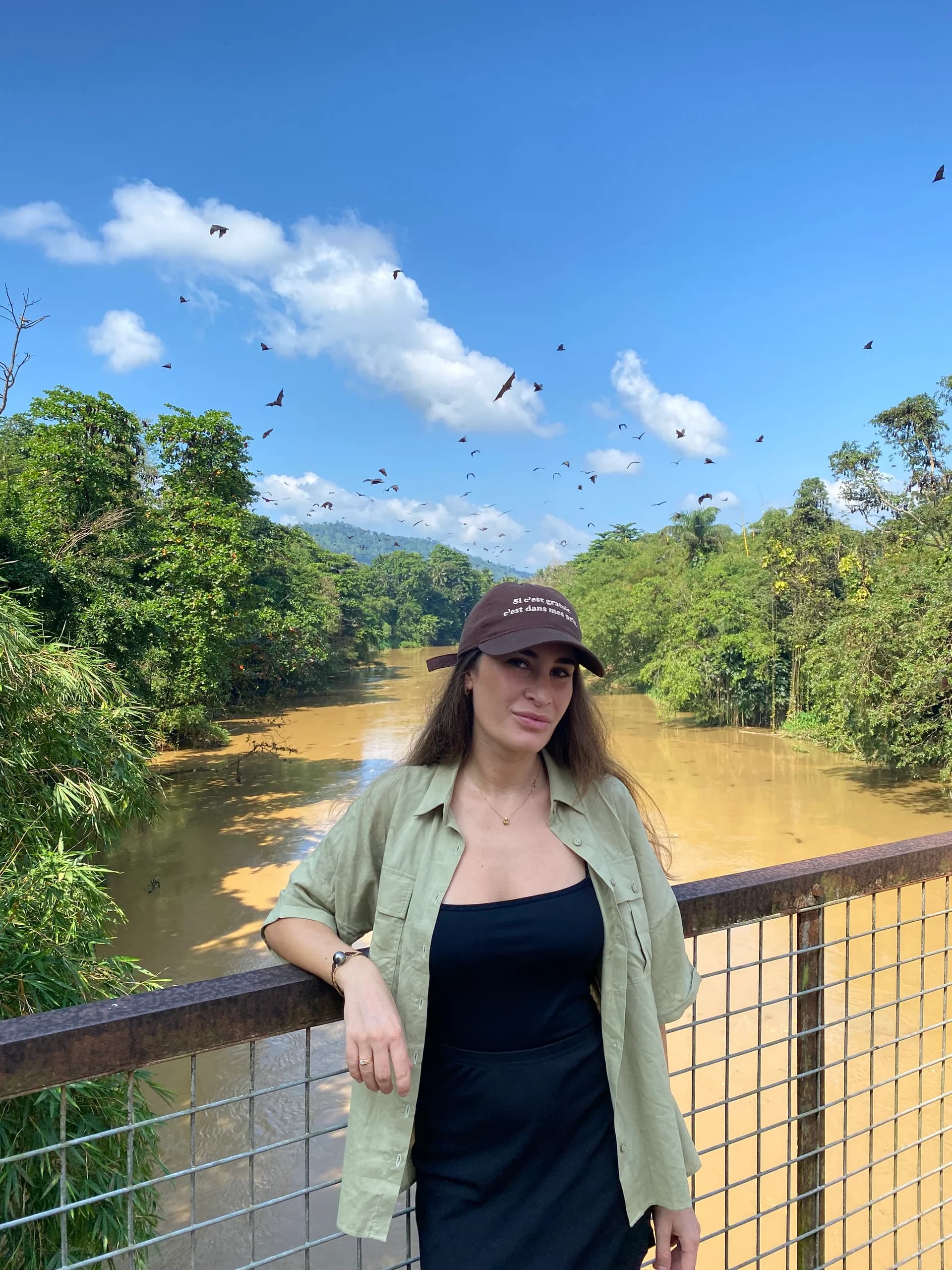 Portrait sur une passerelle au-dessus d'une rivière, en déplacement